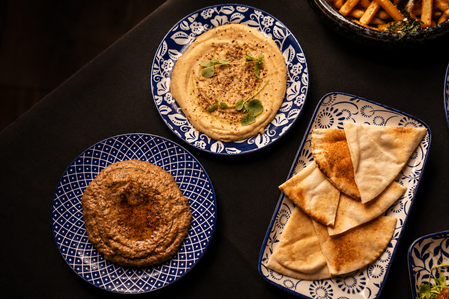 Overhead view of hummus, smoked dips and warm pita